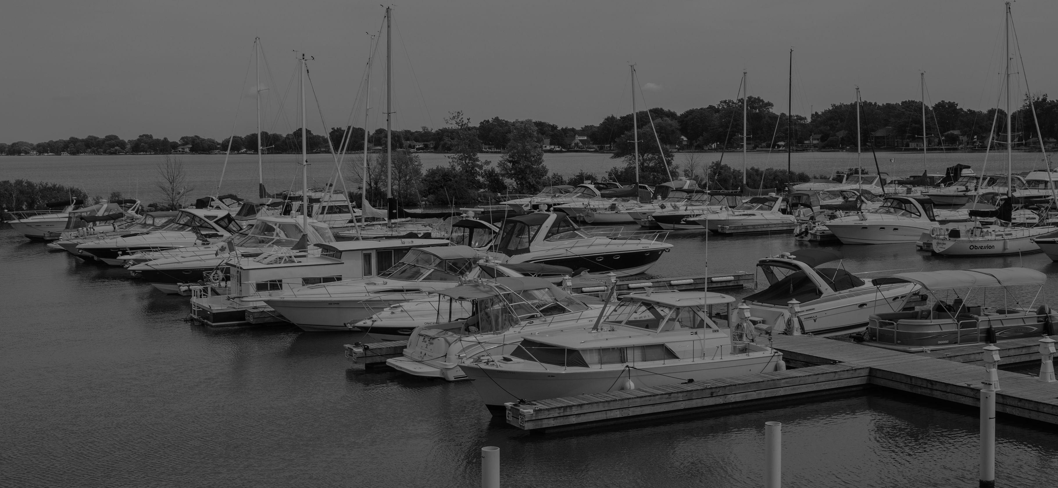 Black-and-white view of boats docked at Belle River Marina in Lakeshore, Ontario.